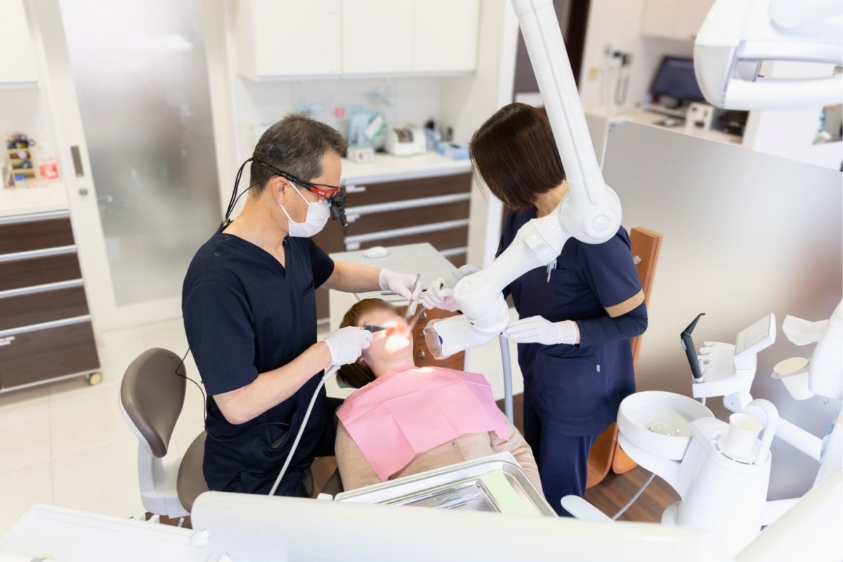 りんせんじ歯科の院長とスタッフが患者さんの治療を行っている